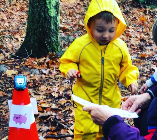Child in yellow raincoat finding the pig checkpoint